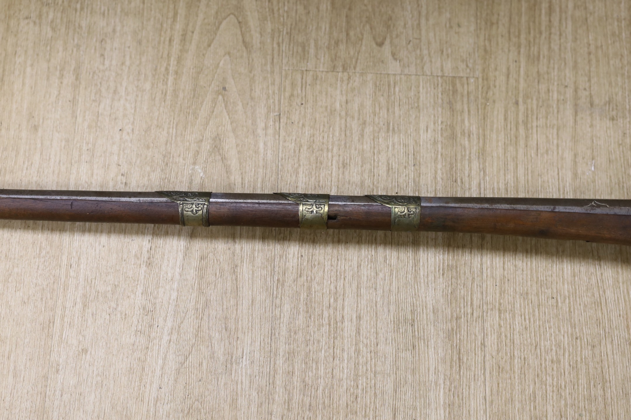 An Eastern decoratively metal mounted antique musket, 132cms long.